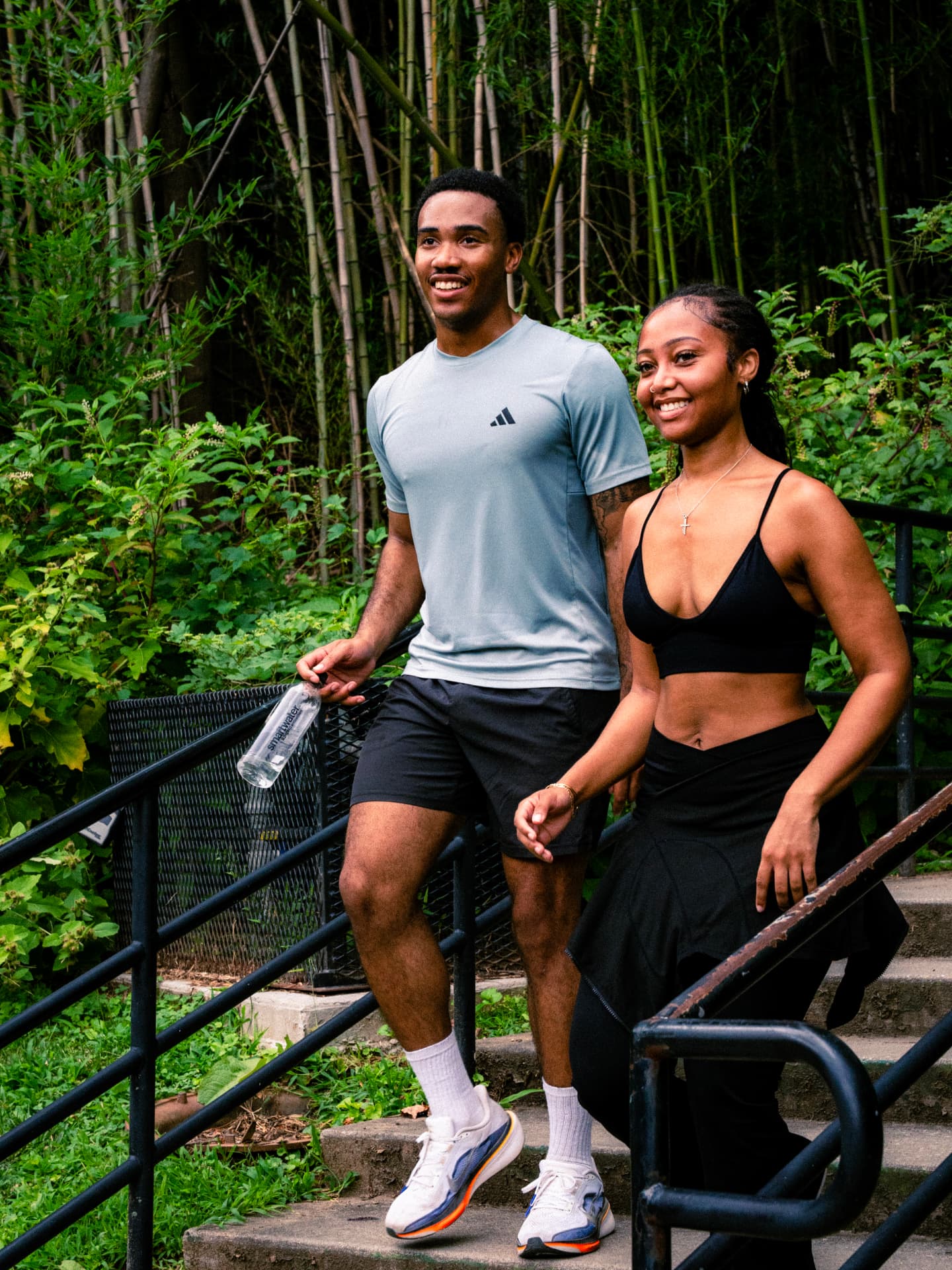 Two runners smiling on the park stairs