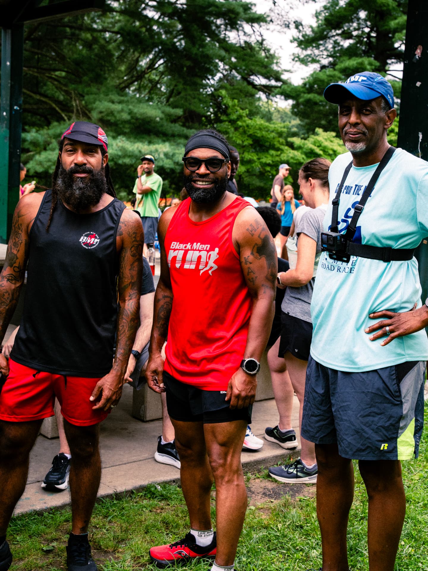 Three runners smiling for the camera in the park
