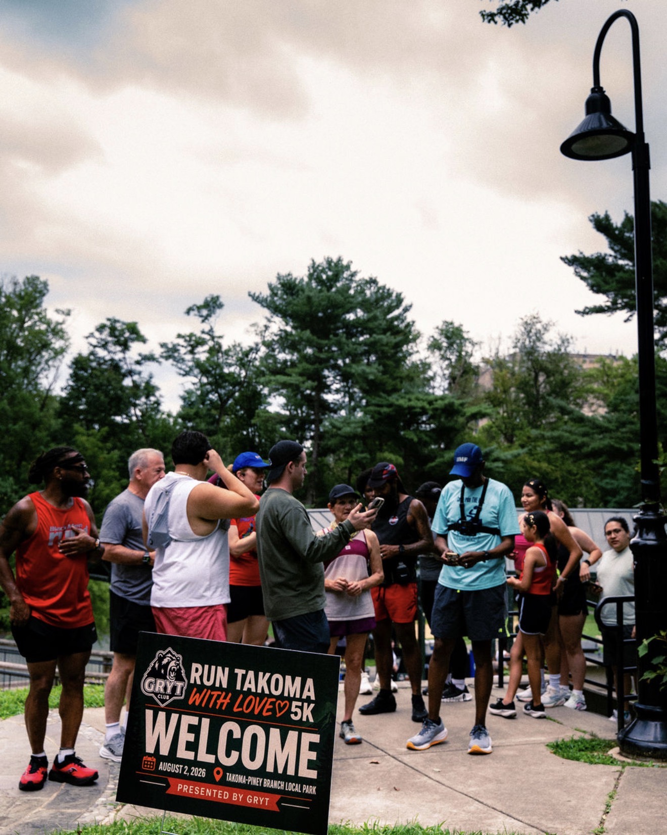 Runners gathered behind the Run Takoma With Love 5K welcome sign
